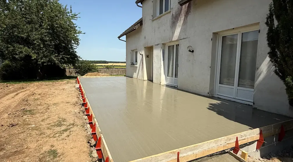 Coulage d'une dalle béton pour terrasse le long d'une maison