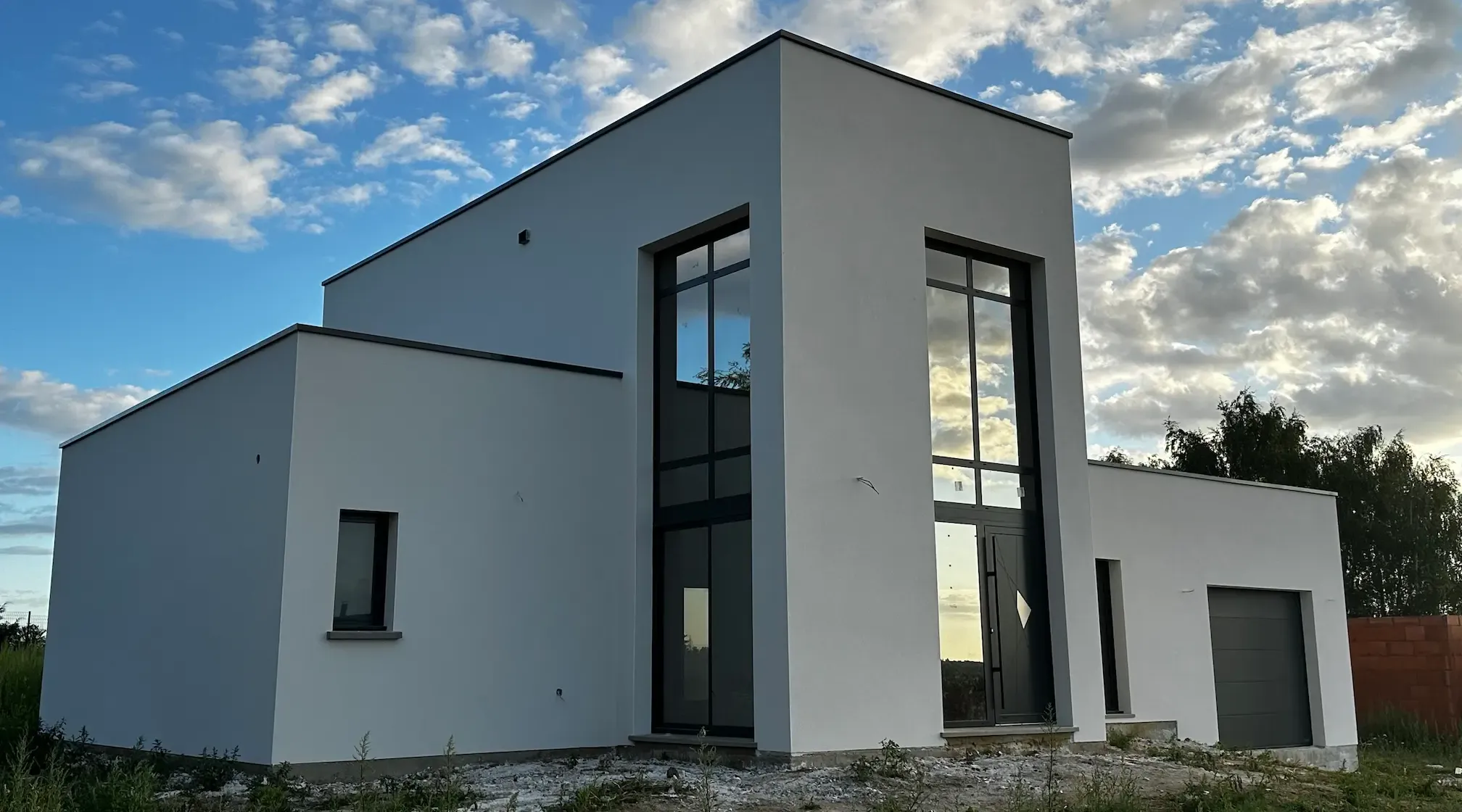 Maison contemporaine blanche avec grandes baies vitrées en cours de finition
