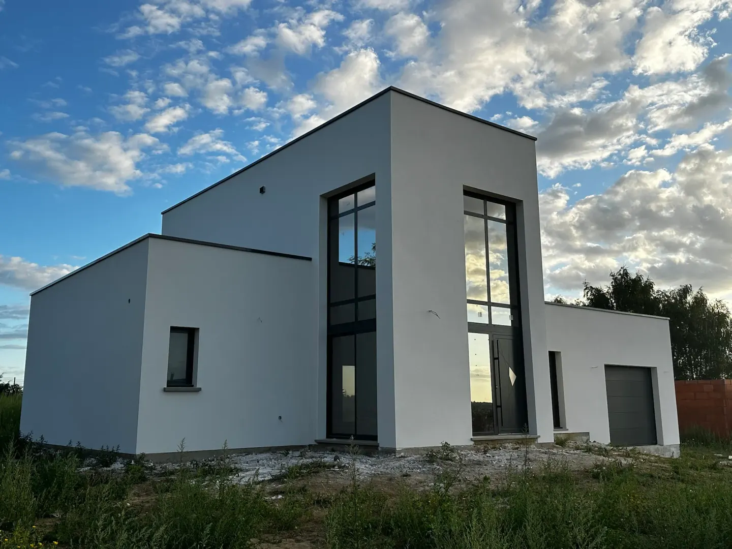 Maison contemporaine blanche avec grandes baies vitrées en cours de finition