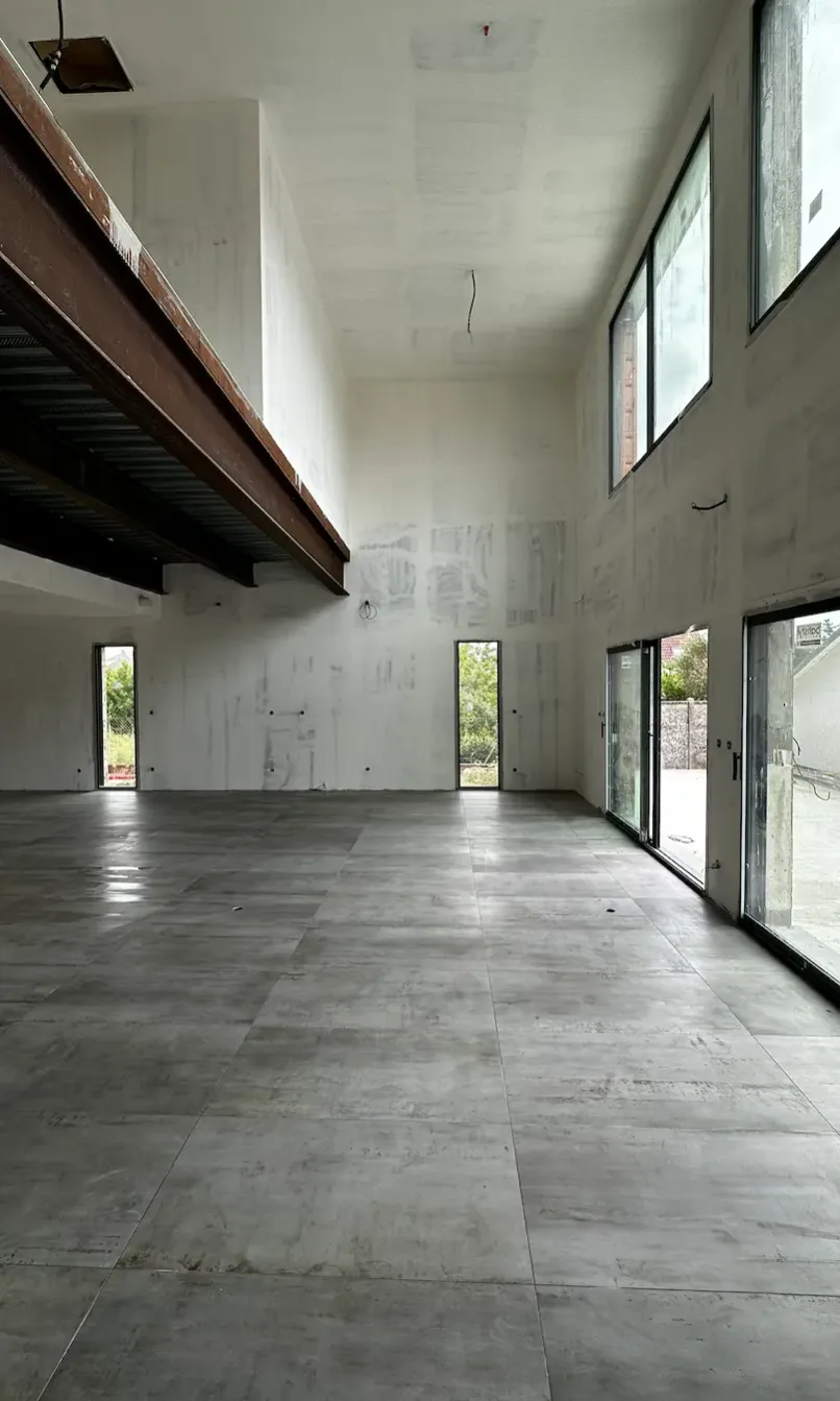 Intérieur d'une maison neuve avec double hauteur et carrelage grand format