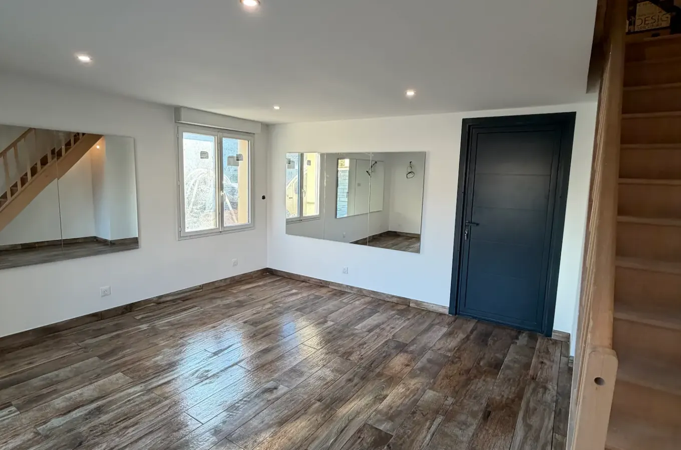 Pièce de vie rénovée avec carrelage imitation bois et escalier