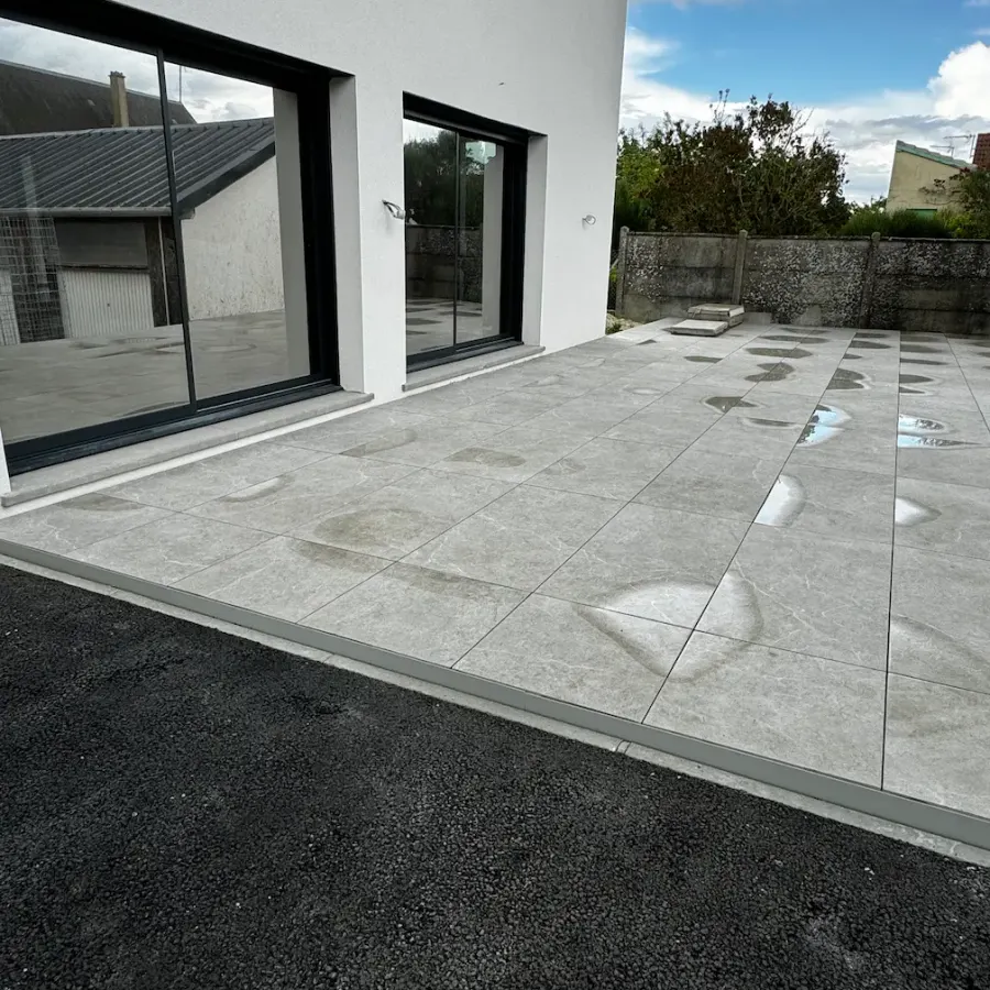 Terrasse en dalles réalisée devant une maison contemporaine